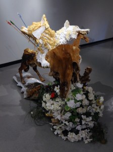 Ysengrimus, Orthus, and Sick Stag  5'9” X 4'7 X 3'5” 2013 tree trunk fragment, neatsfoot oil, oil paint, spray enamel, polymer clay, artificial flora, polystyrene foam, polyurethane foam, bailing wire steel hardware, deer hide (roadkill), polyurethane adhesive, fiberglass arrows, wood, acrylic latex, machine enamel,  broken deer bones, plaster, epoxy, spar urethane 