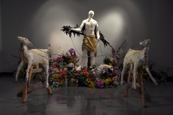 Hierophany  installation approx. 17'X 8'10”X21' 2013  cotton horse foaling blanket, unfired clay, concrete casts of dead deer,  boar tusks, acrylic latex, leather, machine enamel, spray enamel, mannequin hands, goose feathers, oak lumber, untreated pine, steel hardware, plaster, polyurethane, polyurethane adhesive, oil paint, poly-cotton rope, polystyrene foam, polyurethane foam, polymer clay, bailing wire, tar, artificial flora, rhinestone, liquid asphalt, concrete sealant, epoxy 